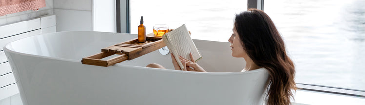 A woman sitting in the bathtub reading her self-care checklist